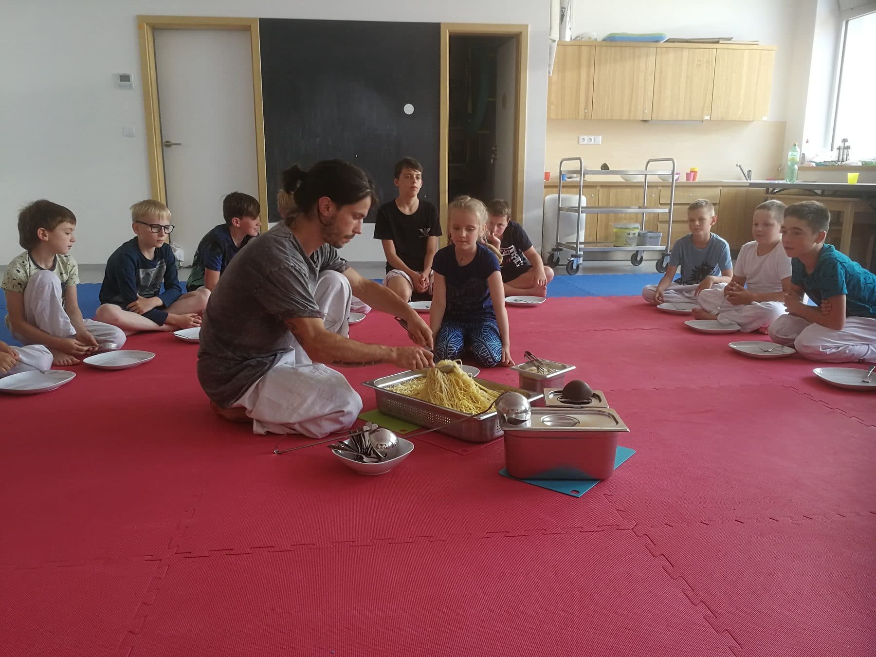 Čajový obřad — děti sedí na tatami a naslouchají trenérovi
